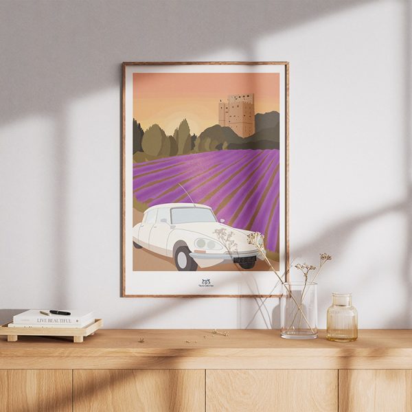 Affiche encadrée avec une Citroën DS devant un champ de lavande et la tour de Crest, réalisée pour un anniversaire, accrochée au-dessus d'une console en bois, Yblou Création.